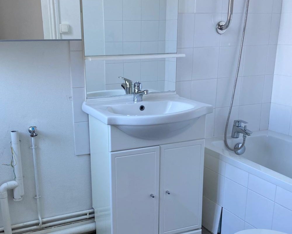 Salle de bain avant travaux du projet Chèvre à Angers, meuble blanc et sol vétuste
